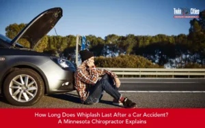 Driver sitting beside a disabled car after a roadside accident, illustrating whiplash injuries and recovery after a car crash.